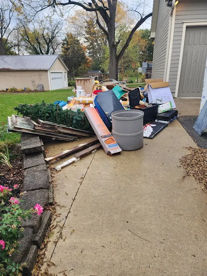 Dumpster being loaded with debris for 12 Yard Dumpster Rental in Palmetto Estates